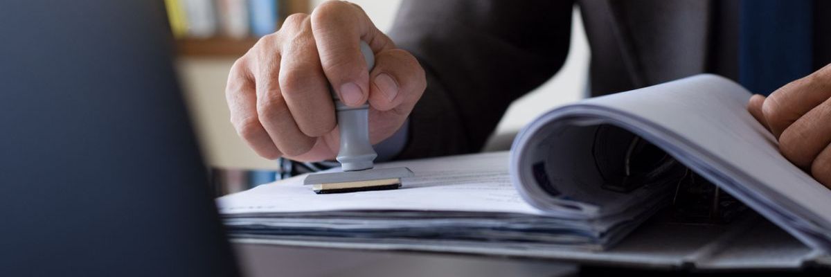 Mitarbeiter eines Veterinäramts stempelt ein Dokument