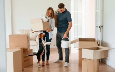 Junges Paar mit Hund bezieht eine neue Wohnung